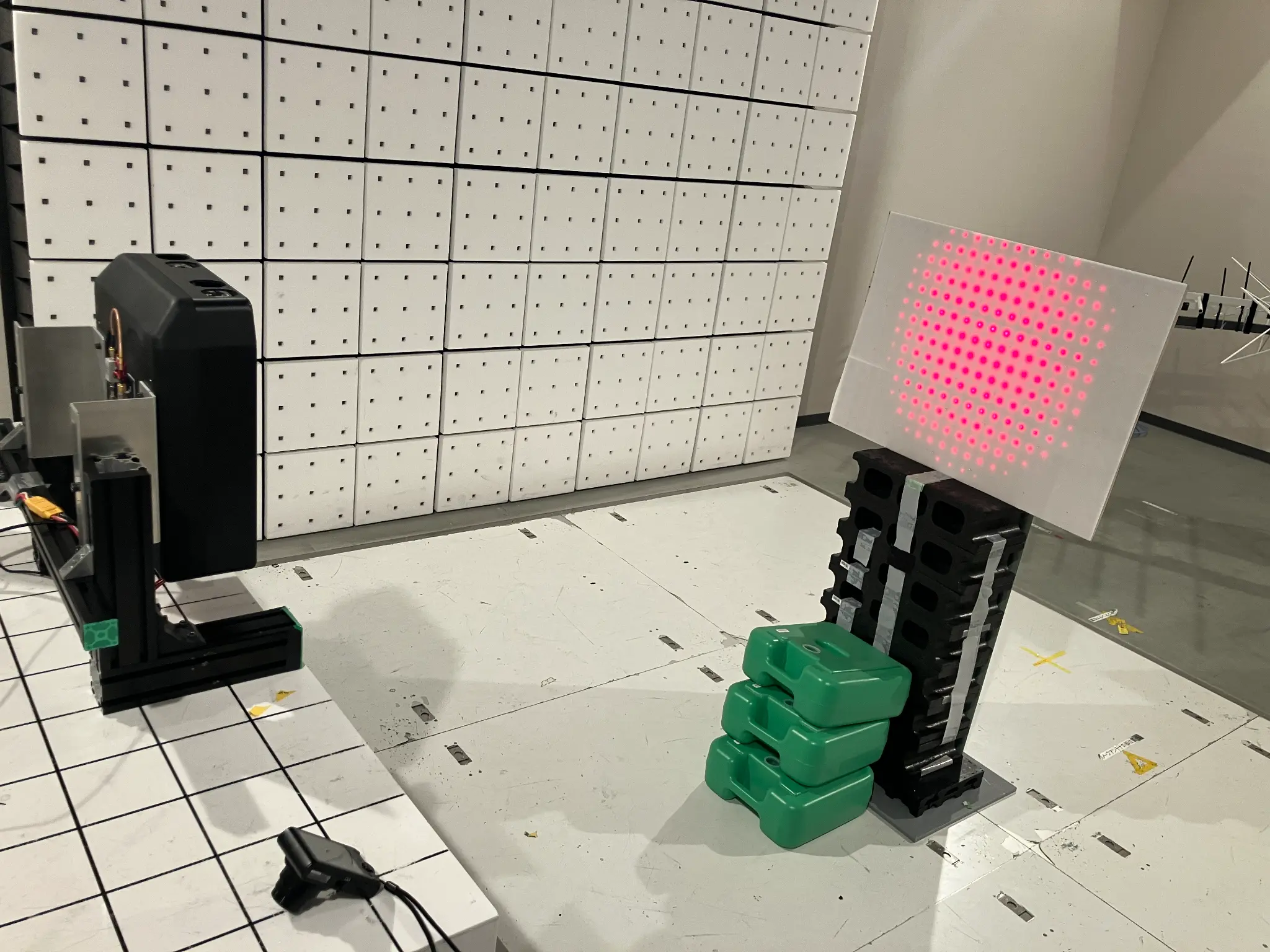 フェイズドアレーアンテナによるビームフォーミングの実機写真：送電装置（左）から受電パネル（右）へマイクロ波ビームを照射している実証実験の様子