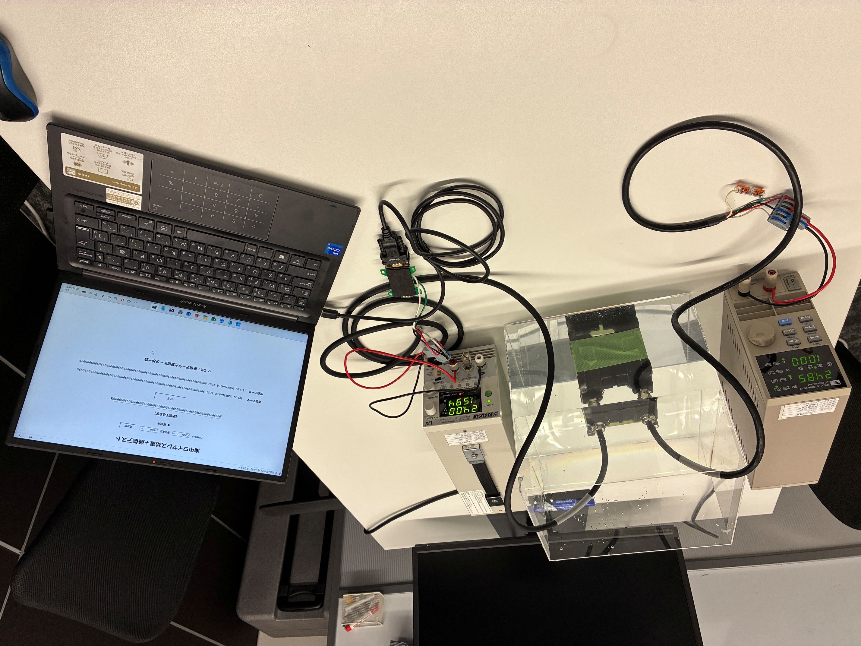 PC、電源、電子負荷と人工海水を入れた水槽を使った給電・通信試験の全景